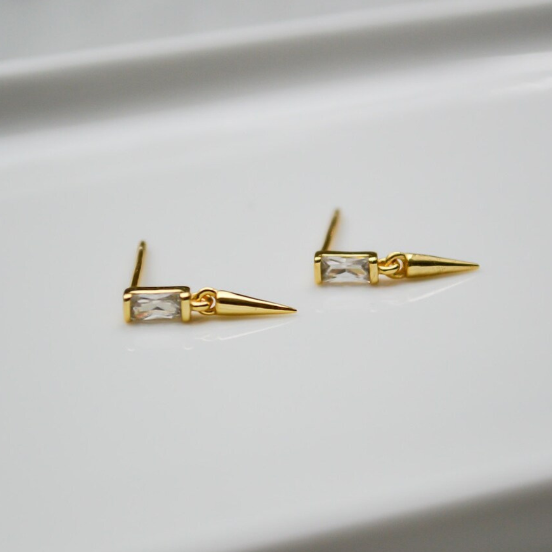 Zierliche goldene Spike Ohrstecker mit je einem weißen, rechteckigen Zirkonia veredelt.