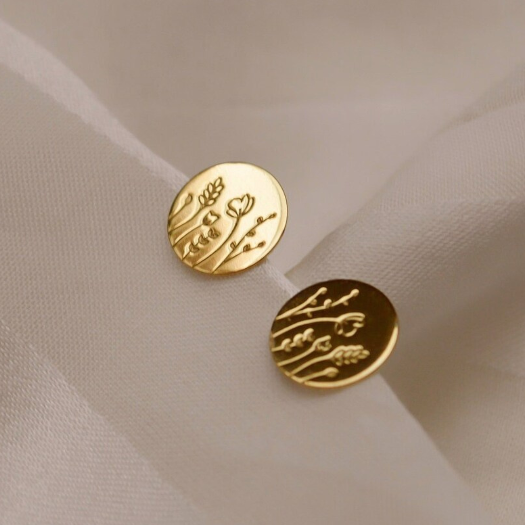 Goldene Plättchen Ohrstecker mit zart eingeprägtem Blumenwiesen Motiv.