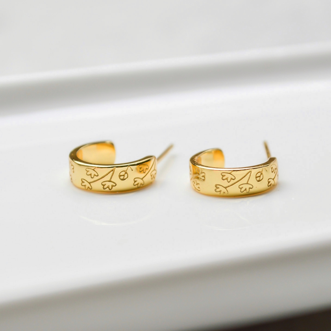 Elegante goldene Halbcreolen mit zartem Blumenmuster