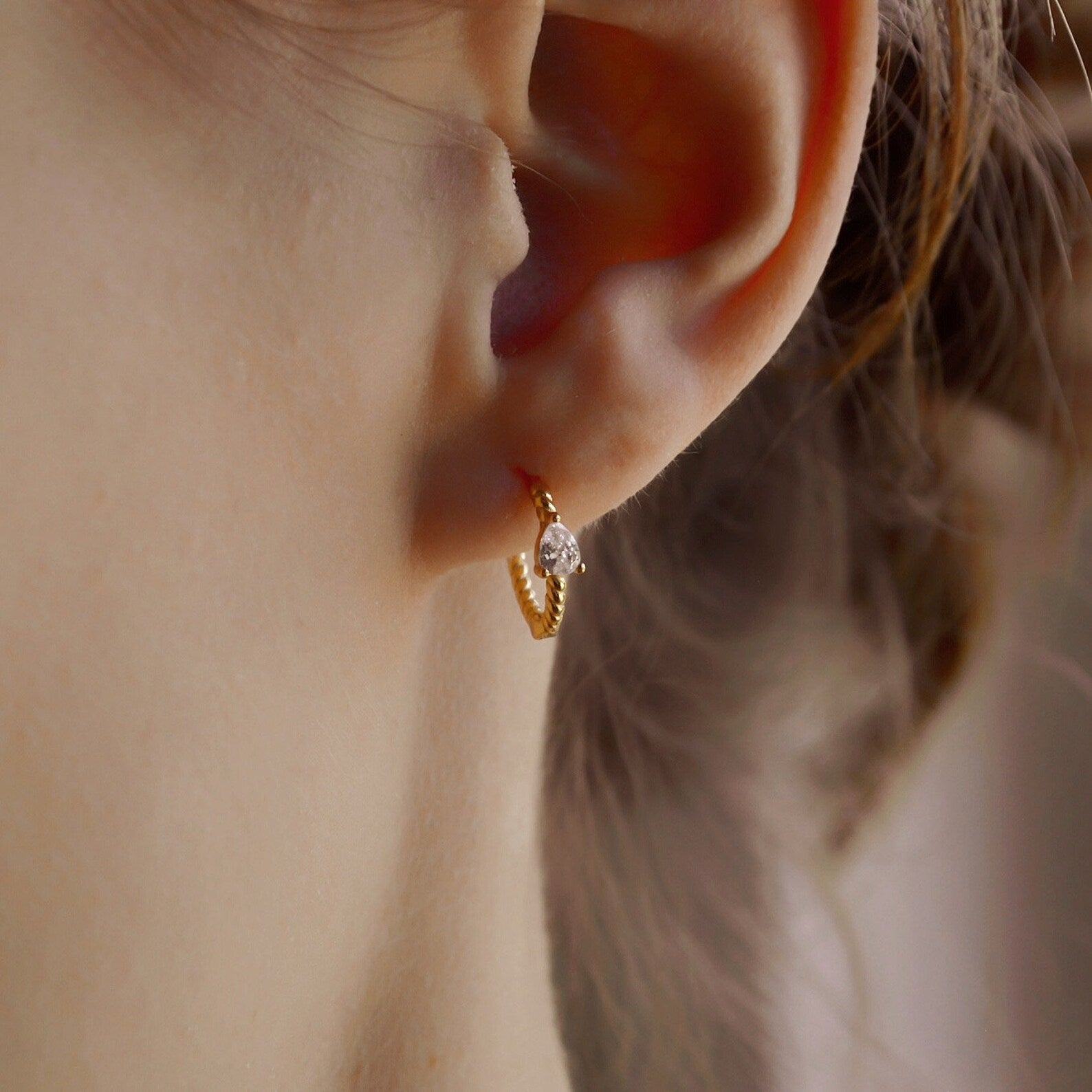 "Raja" gedrehte Creolen mit Zirkonia in Tropfenform