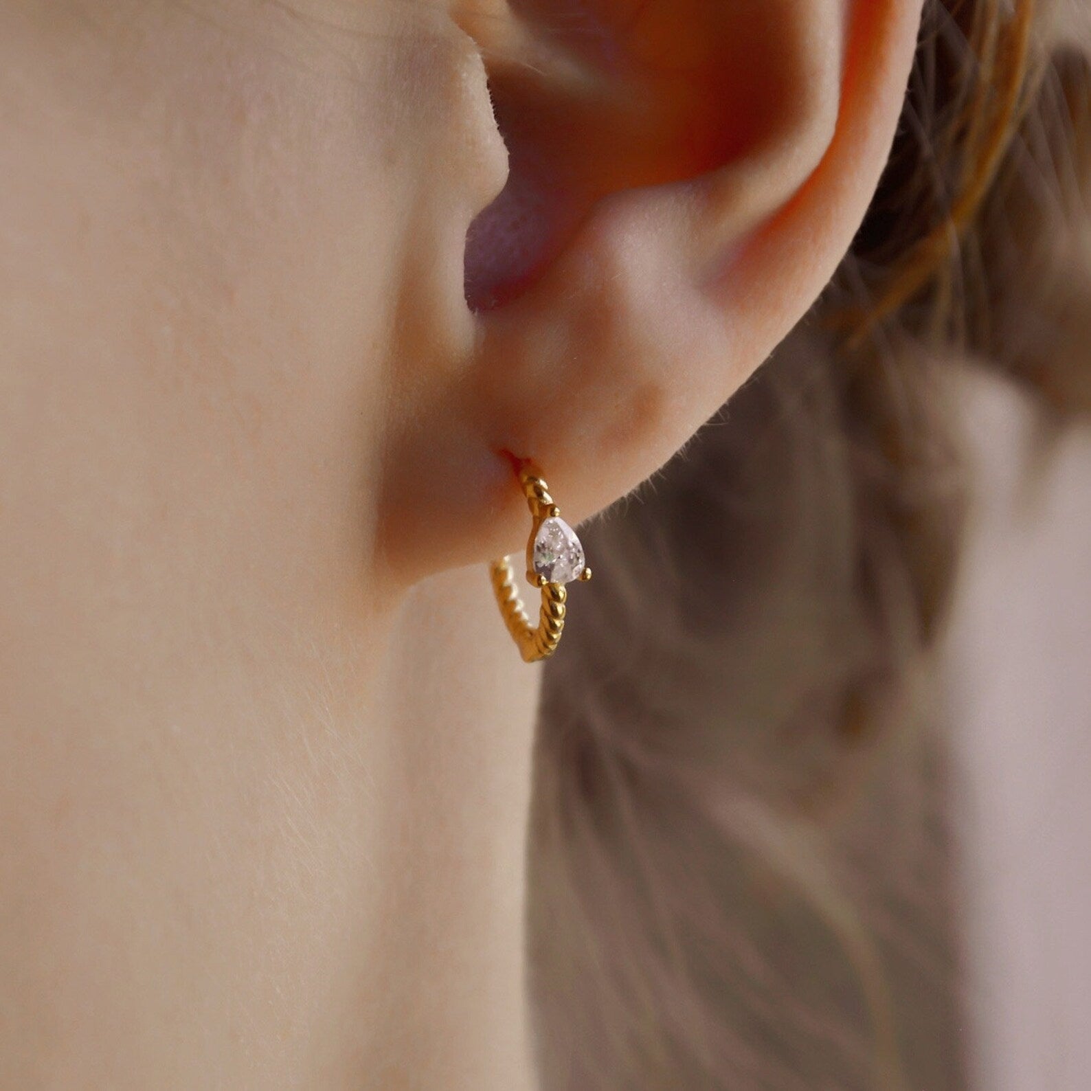 "Raja" gedrehte Creolen mit Zirkonia in Tropfenform