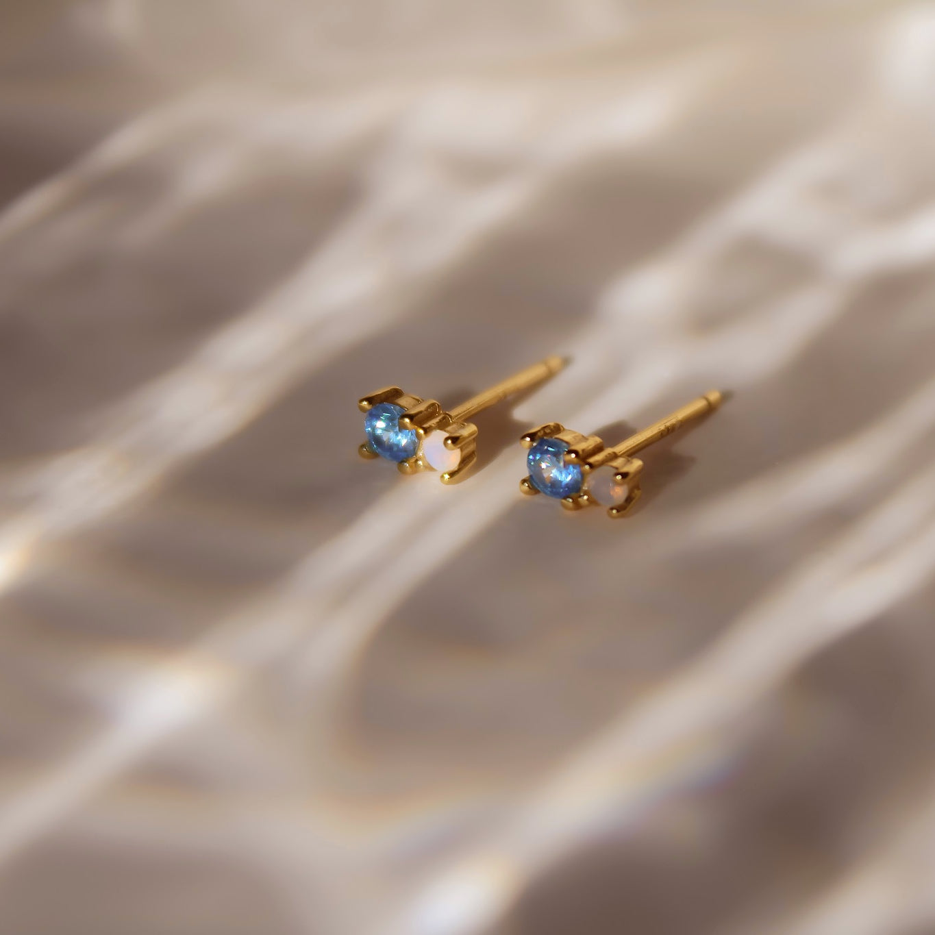 "Yuna" winzige goldene Ohrstecker mit blauem Zirkonia und Mondstein