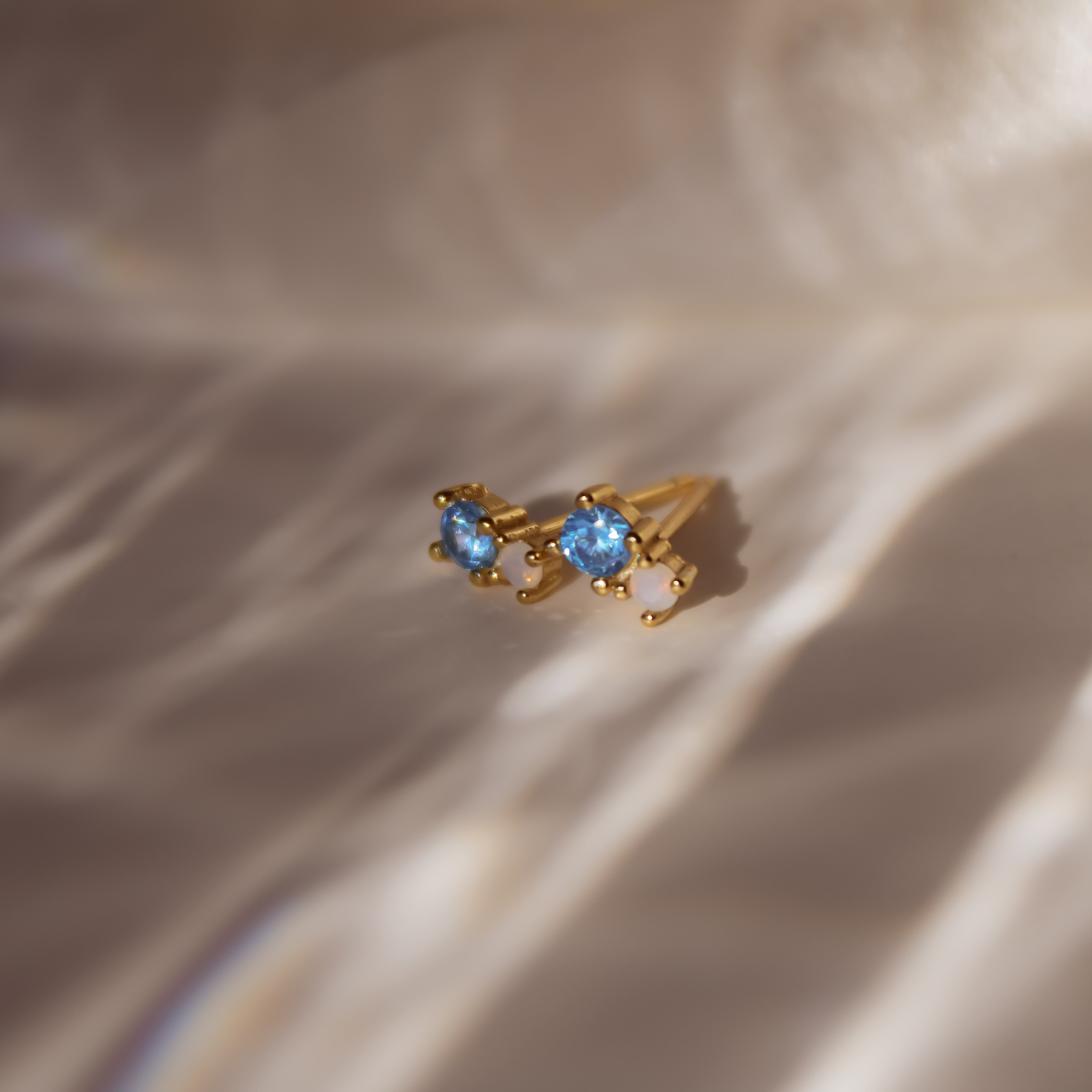 "Yuna" winzige goldene Ohrstecker mit blauem Zirkonia und Mondstein