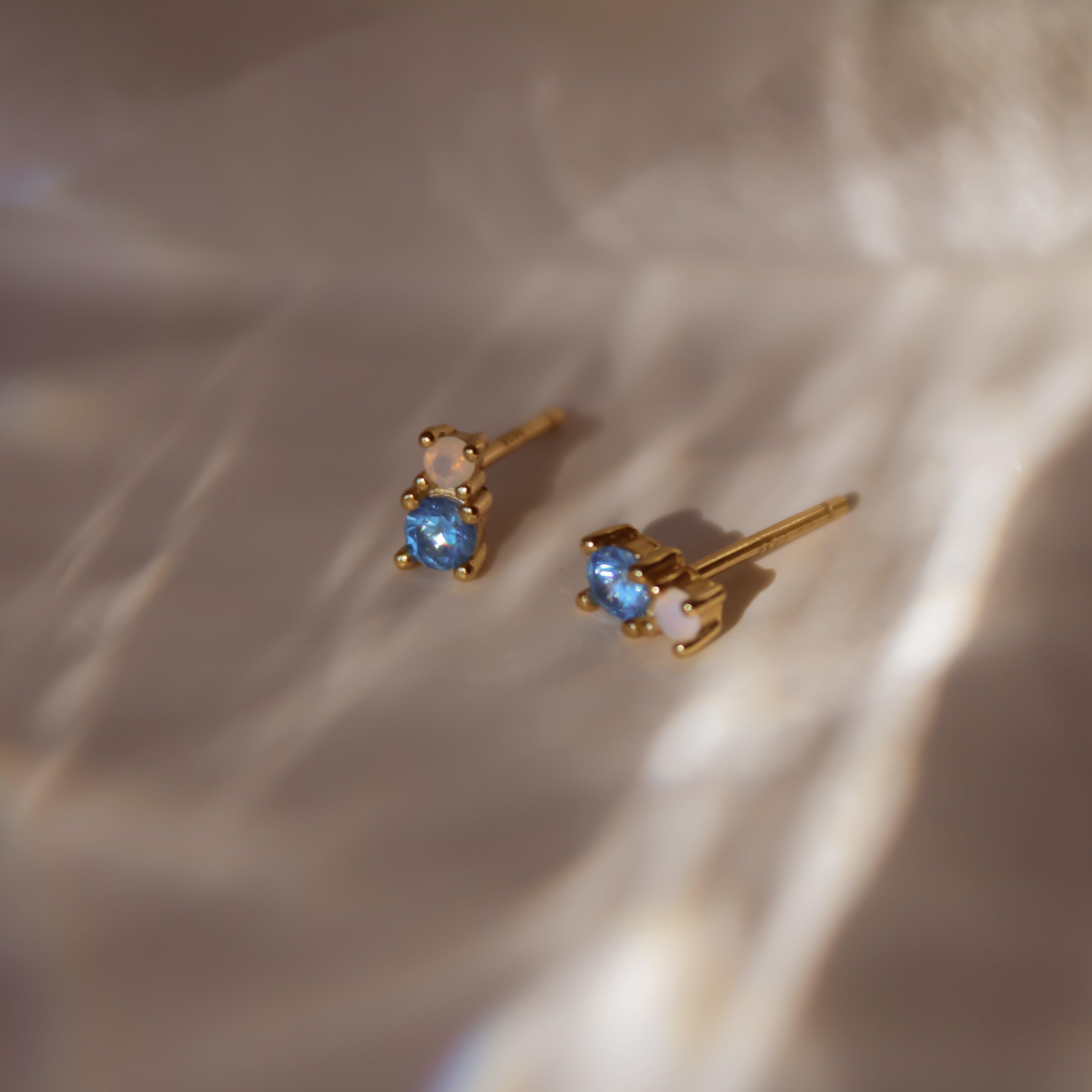 "Yuna" winzige goldene Ohrstecker mit blauem Zirkonia und Mondstein