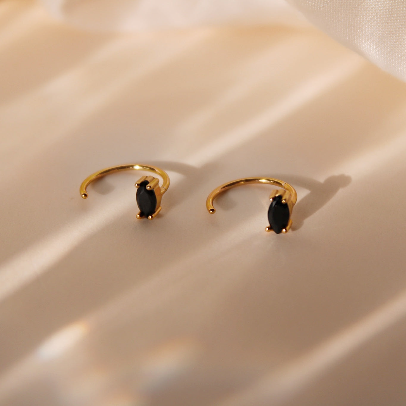 "Claire" Goldene Huggie Hoops mit ovalem schwarzem Zirkonia