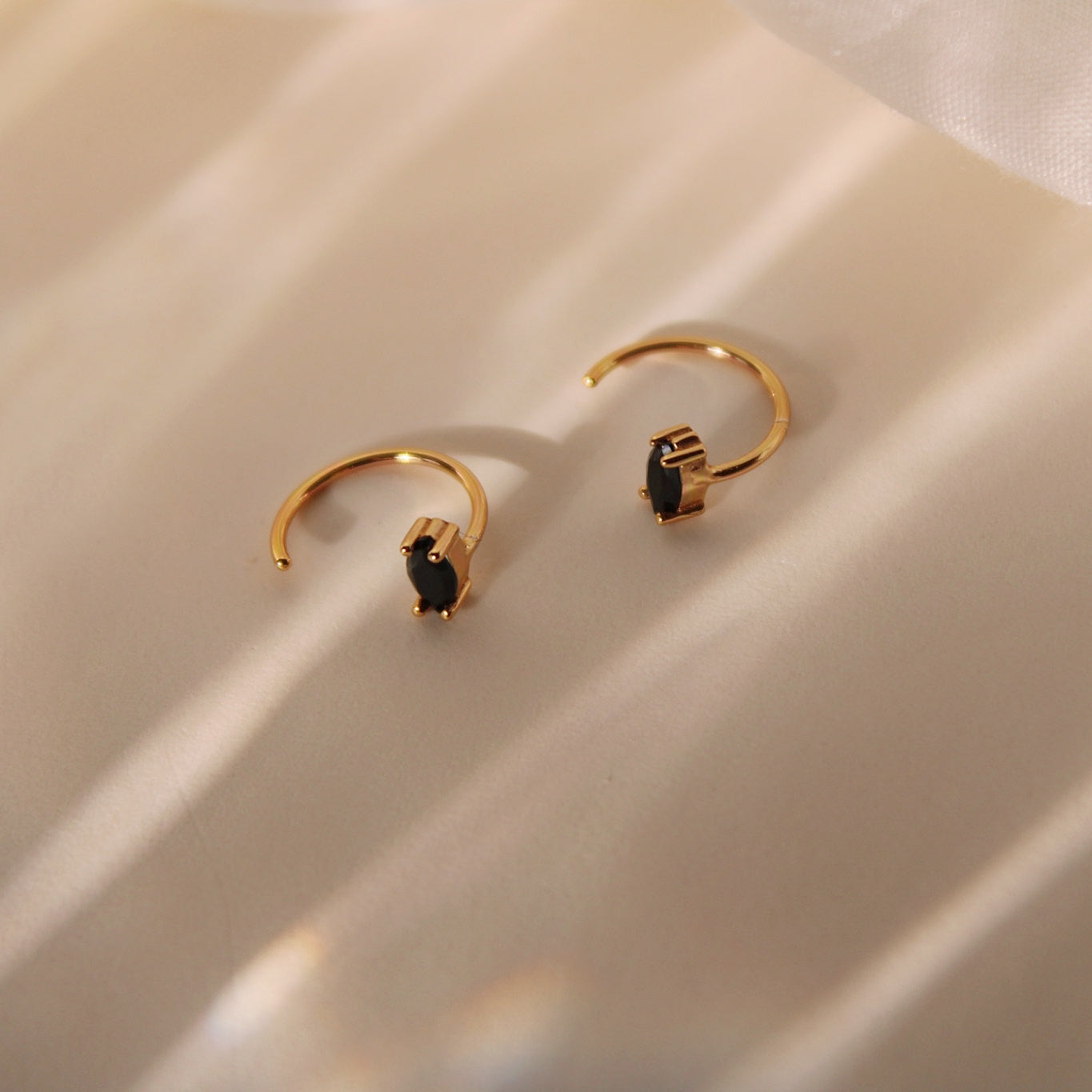 "Claire" Goldene Huggie Hoops mit ovalem schwarzem Zirkonia