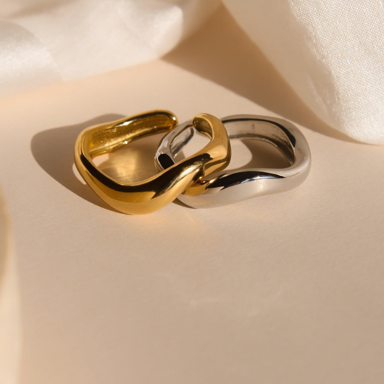 Elegant geschwungene Edelstahl Ringe in Silber und 18 Karat Gold.