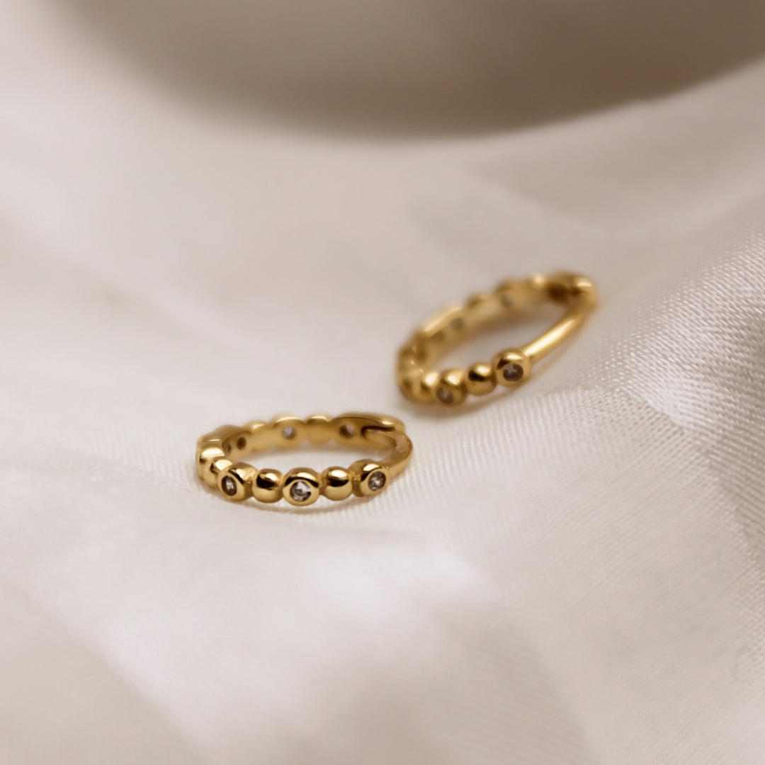 Zierliche Gold Creolen mit winzigen Kügelchen und Zirkonia Steinchen verziert.